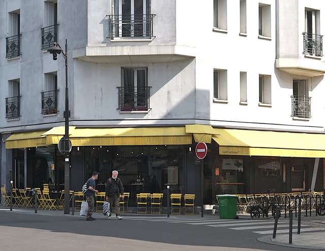 Stores jaunes et tables du Petit Cambodge rue Alibert, en 2024