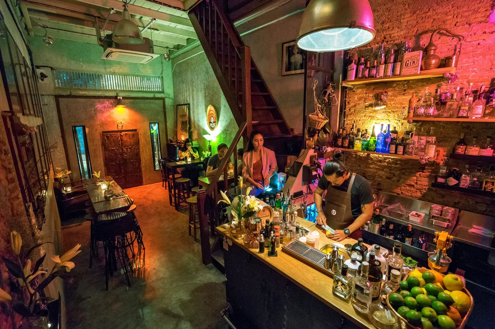 Teens of Thailand: guests and bartenders around the colourful, closely packed cocktail counter