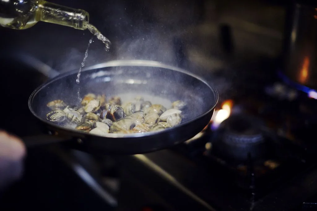 Food cooking in a pan on the restaurant stove at Bacaro