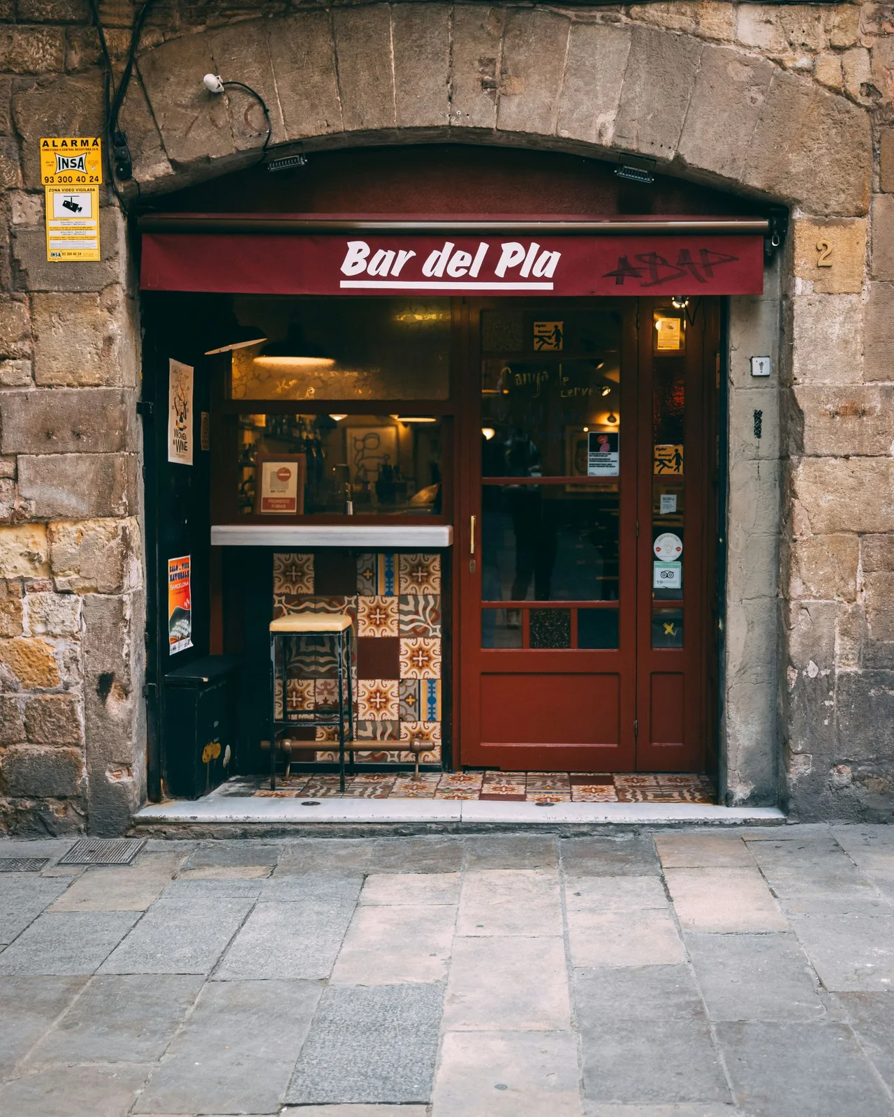 Bar del Pla: the tapas bar's green doorway in the stone-lined street