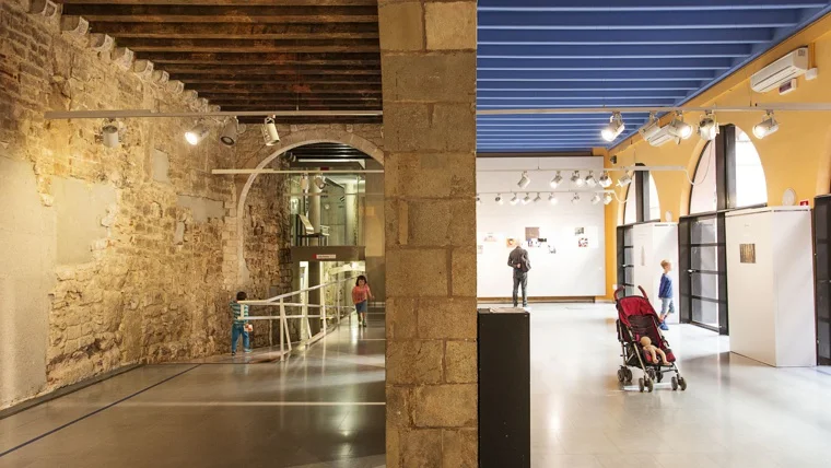 Historic stone walls beside the civic centre's glazed entrance at Centre Cívic Pati Llimona