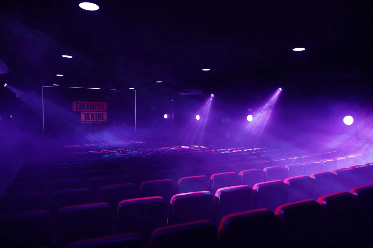 Eixample Teatre: the theatre's seating and stage under purple performance lighting