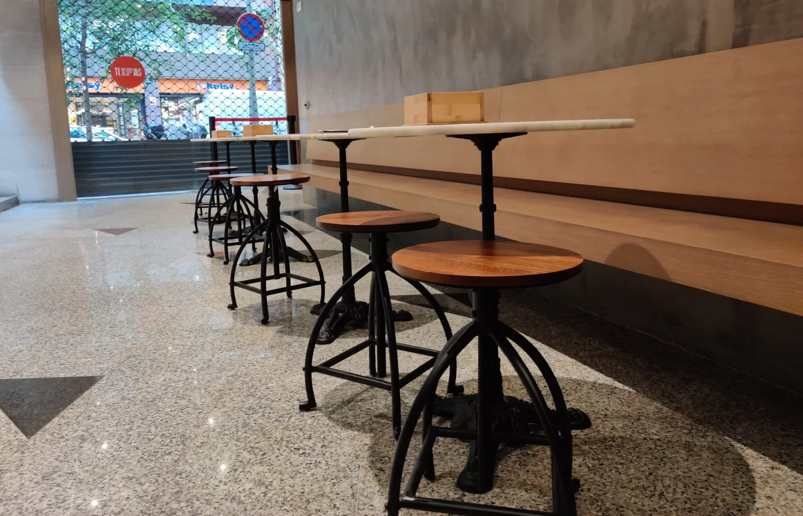 Small tables and stools beside the cinema bar at Espai Texas