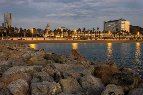 Espigó del Gas: the waterfront seen from the rocky breakwater at dusk