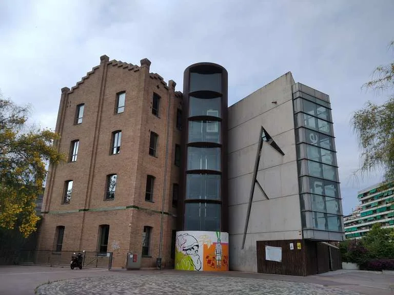 La Farinera del Clot: the former mill's brick tower and contemporary glass extension