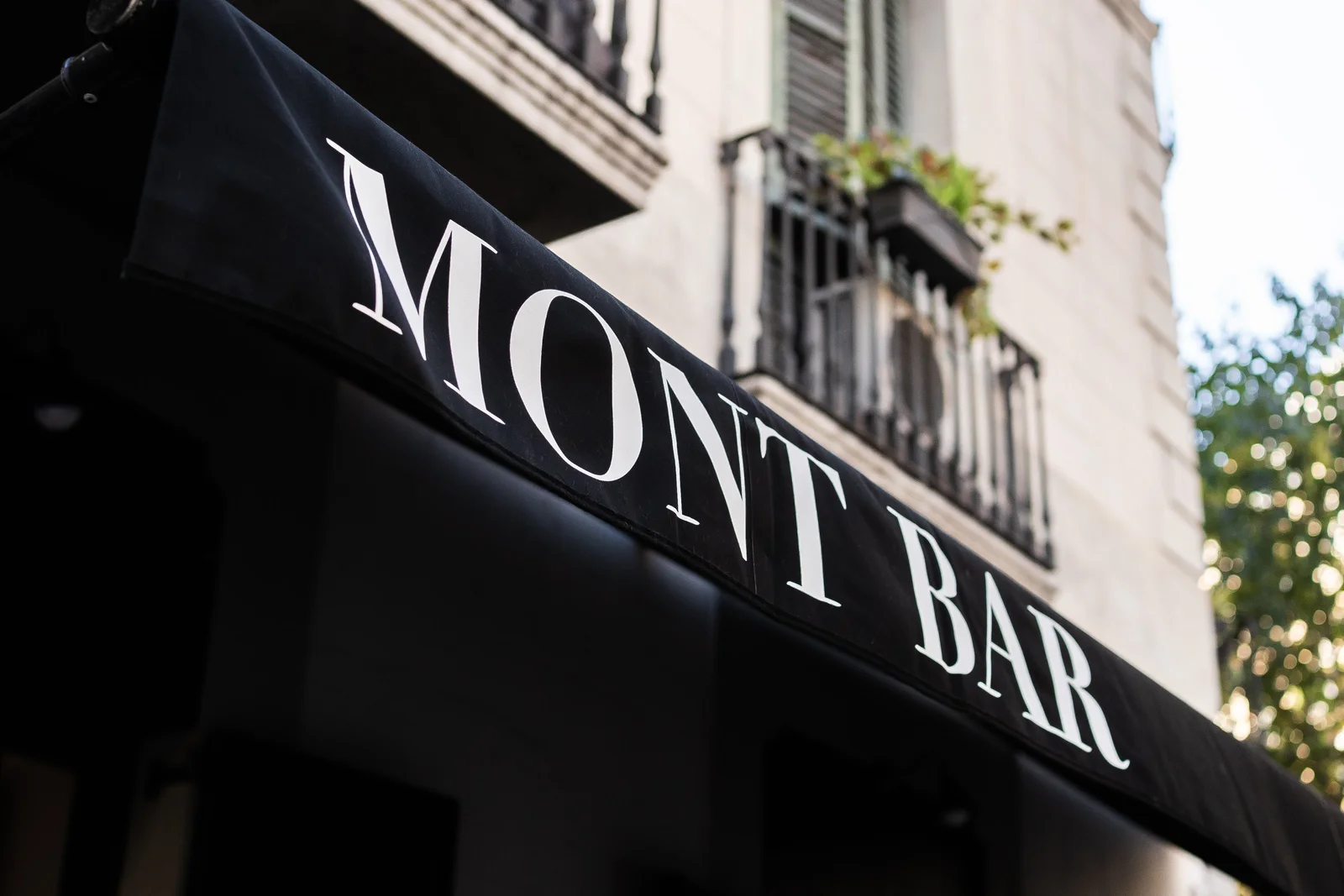 The restaurant name on a black street-side awning at Mont Bar