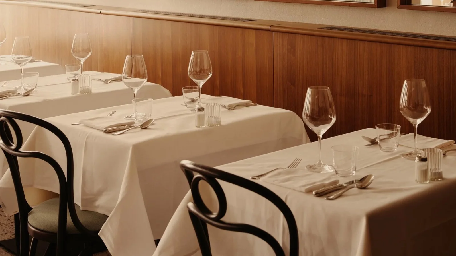 Wood panelling and neatly set dining tables at Bardele