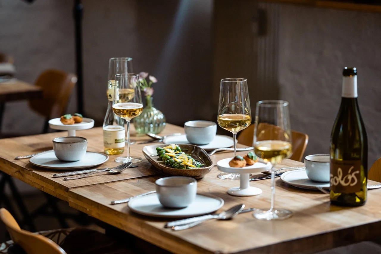 A dining table set with wine, glasses and food at MaMi's