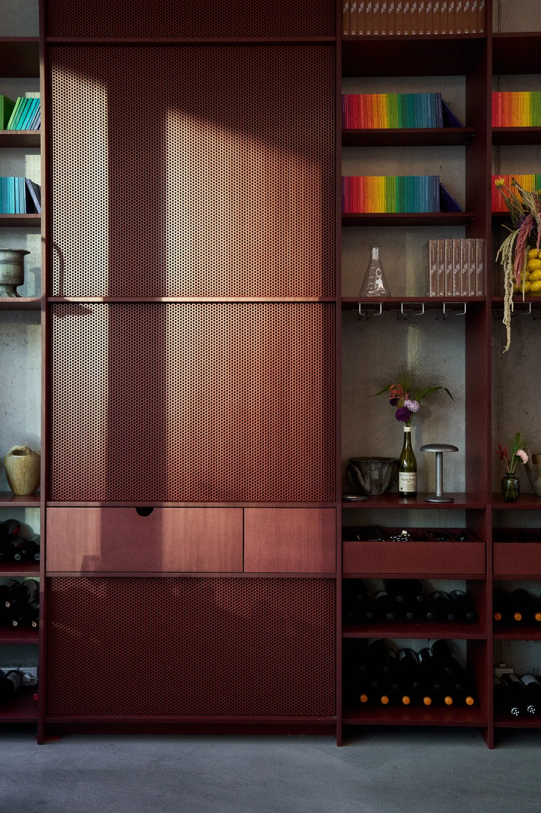 A red-toned cabinet and restaurant interior detail at Remi