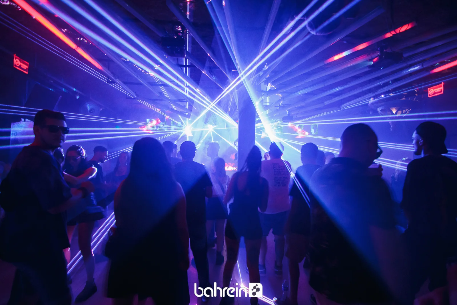 Público bailando bajo luces láser azules y rosas en Bahrein, Buenos Aires