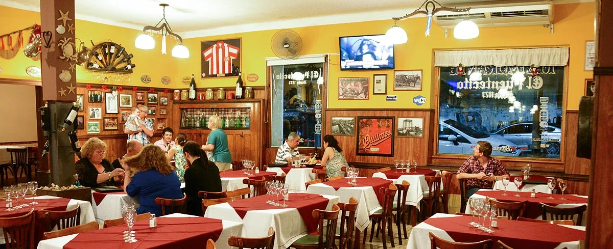 A colourful dining room filled with framed pictures at El Puentecito