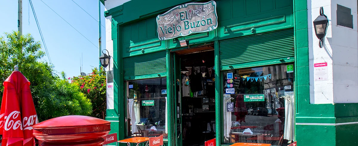 A green-painted corner cafe beside a red postbox at El Viejo Buzón