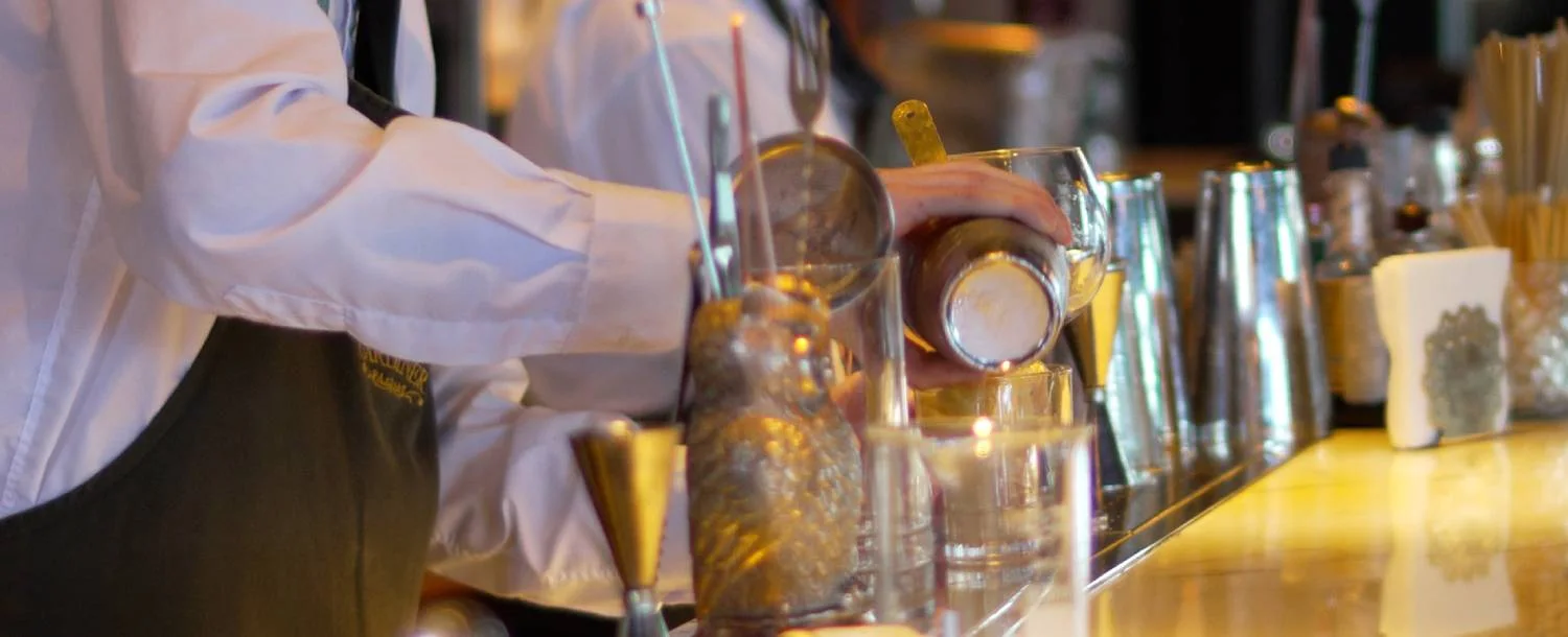 A bartender preparing a drink at the counter at Gardiner