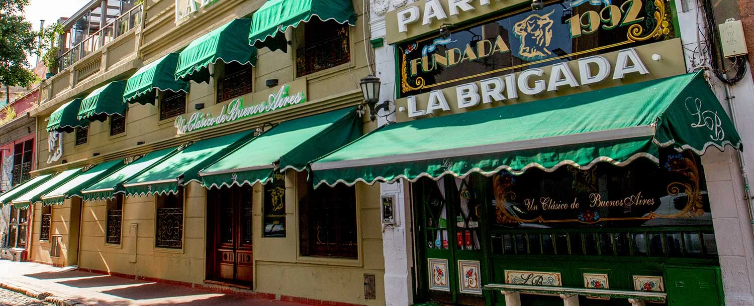 The restaurant's green awnings and signed street frontage at La Brigada