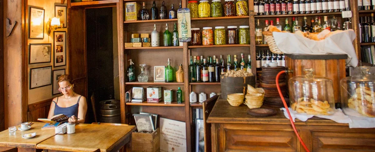Wooden shelves and a small table inside the cafe at La Poesía