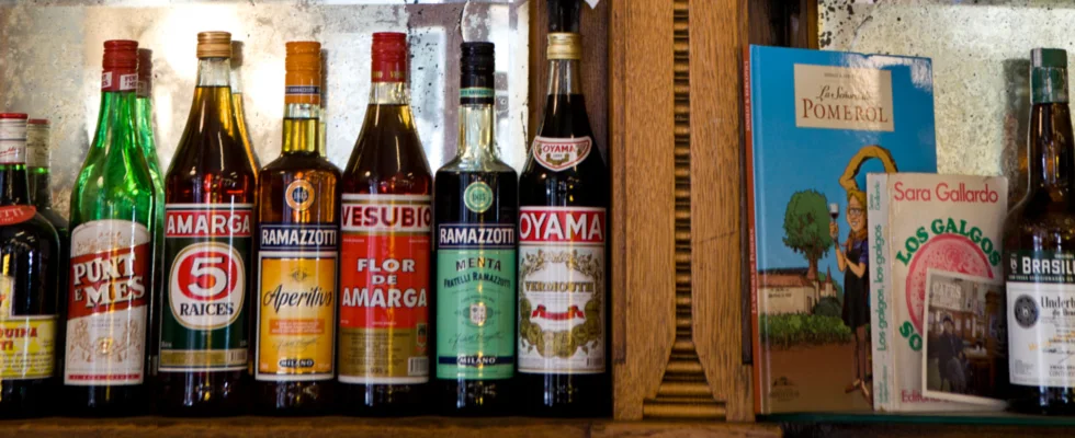 Bottles of aperitif arranged along wooden shelves at Los Galgos