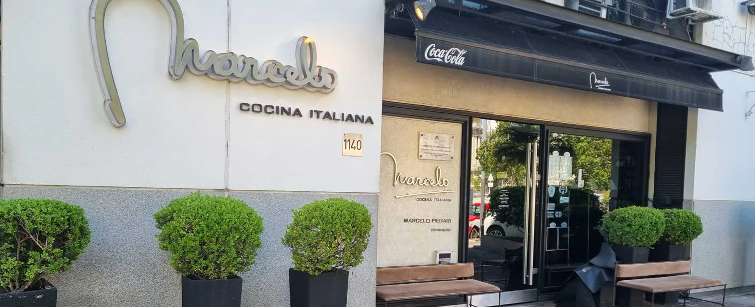The restaurant's signed entrance framed by planted pots at Marcelo Restaurante