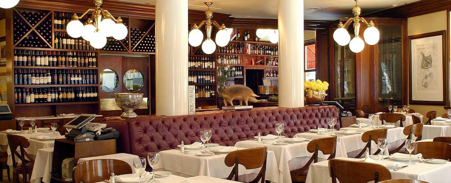A dining room with burgundy seating and wine displays at Oviedo