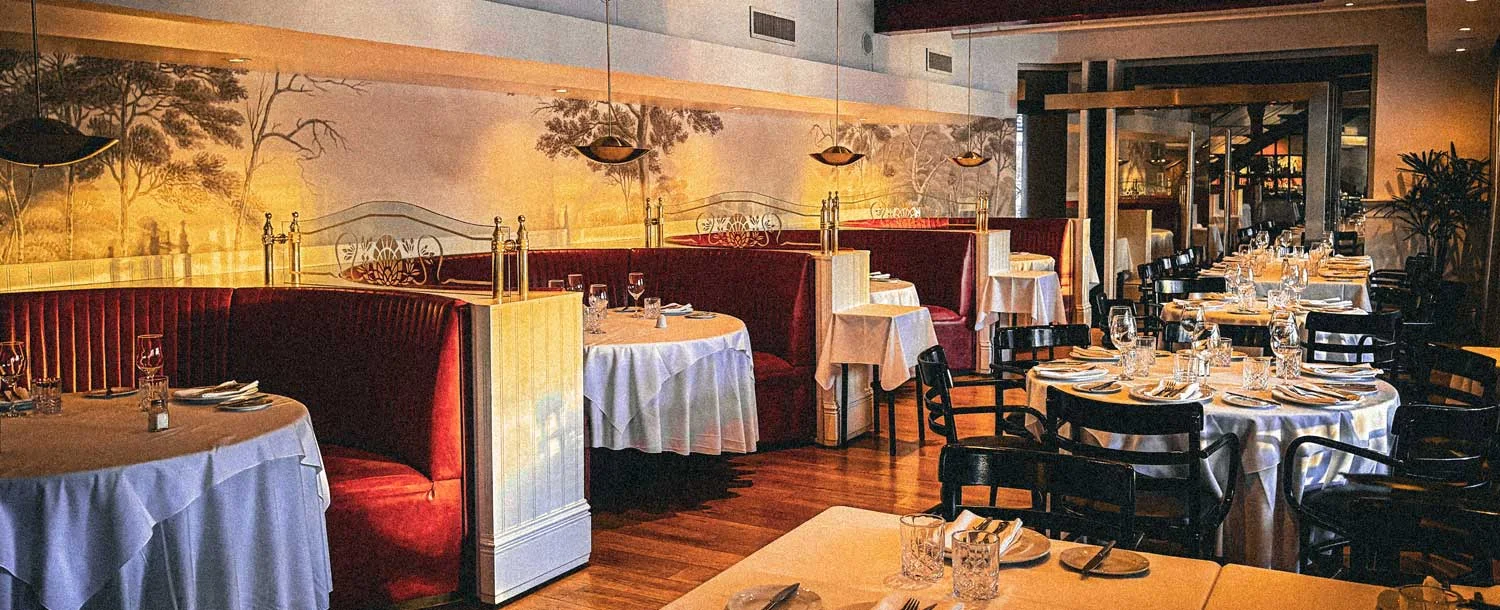 Dining tables beneath the restaurant's illustrated walls at Sorrento Puerto Madero