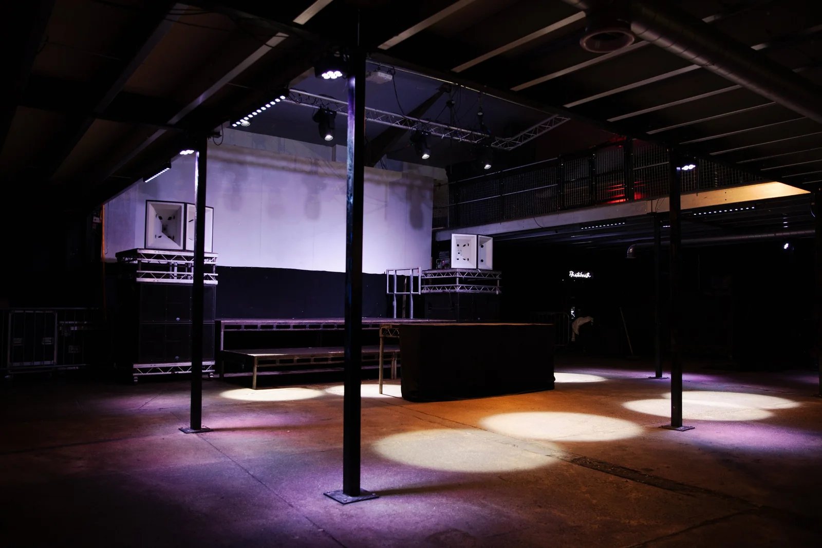 An industrial dance floor beneath steel beams at Colour Factory