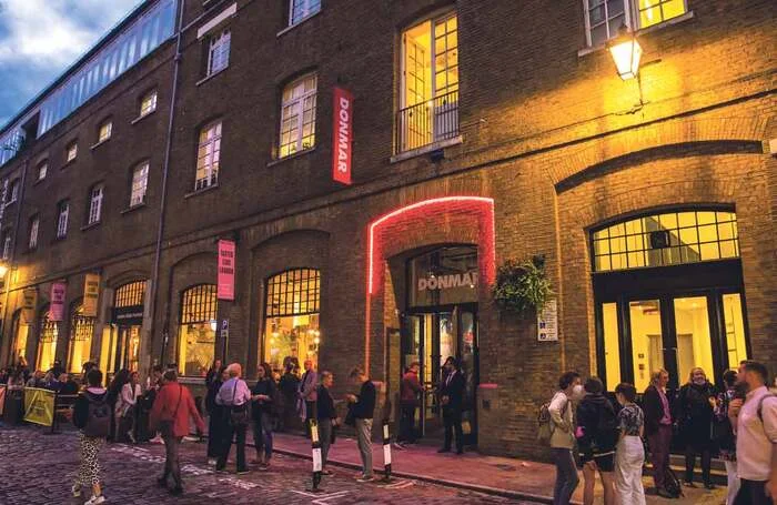Donmar Warehouse: the theatre's brick entrance glowing warmly after dark