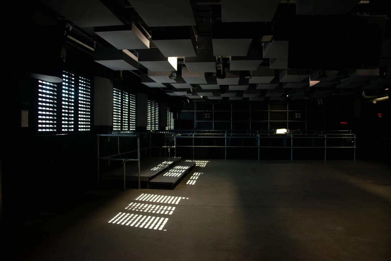 FOLD: daylight cutting through the shutters into the industrial club space