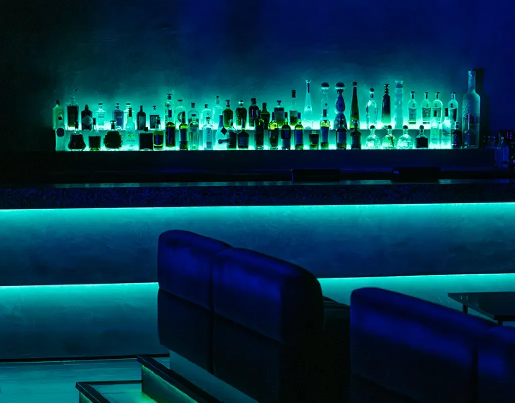 A dark bar illuminated by blue and green lights at Ministry of Sound
