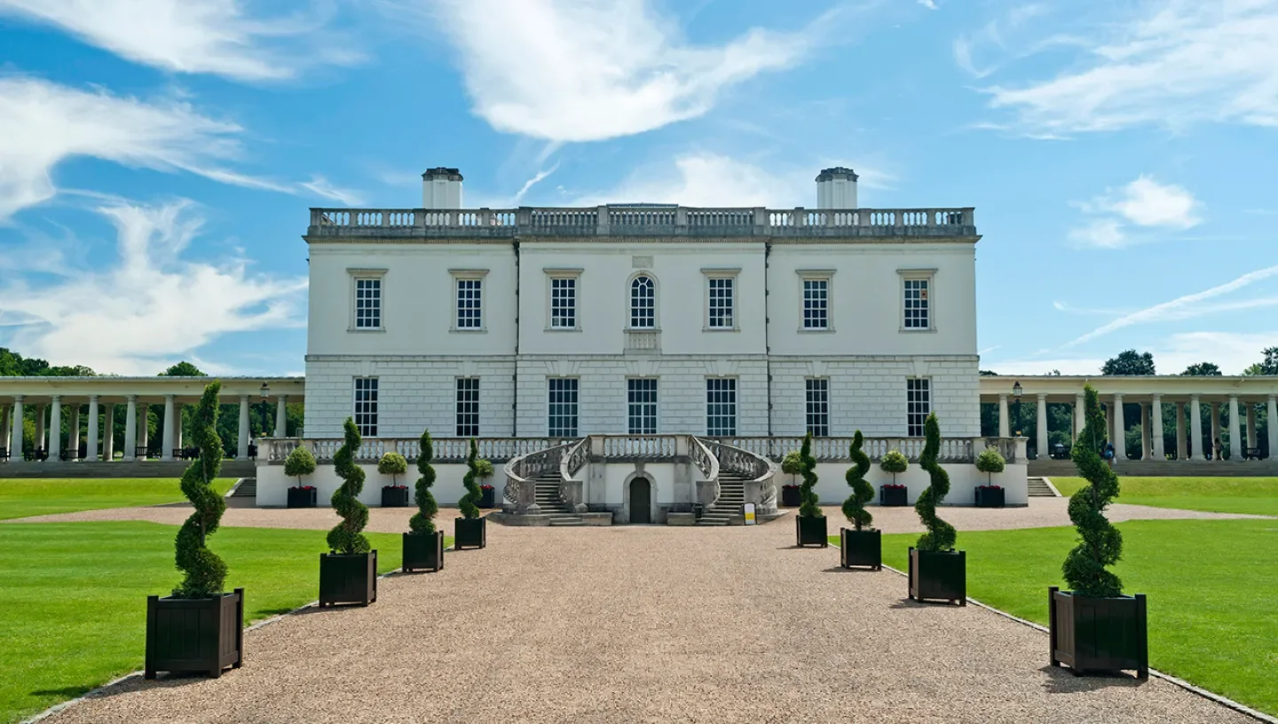 The white facade and formal approach to the historic house at Queen’s House