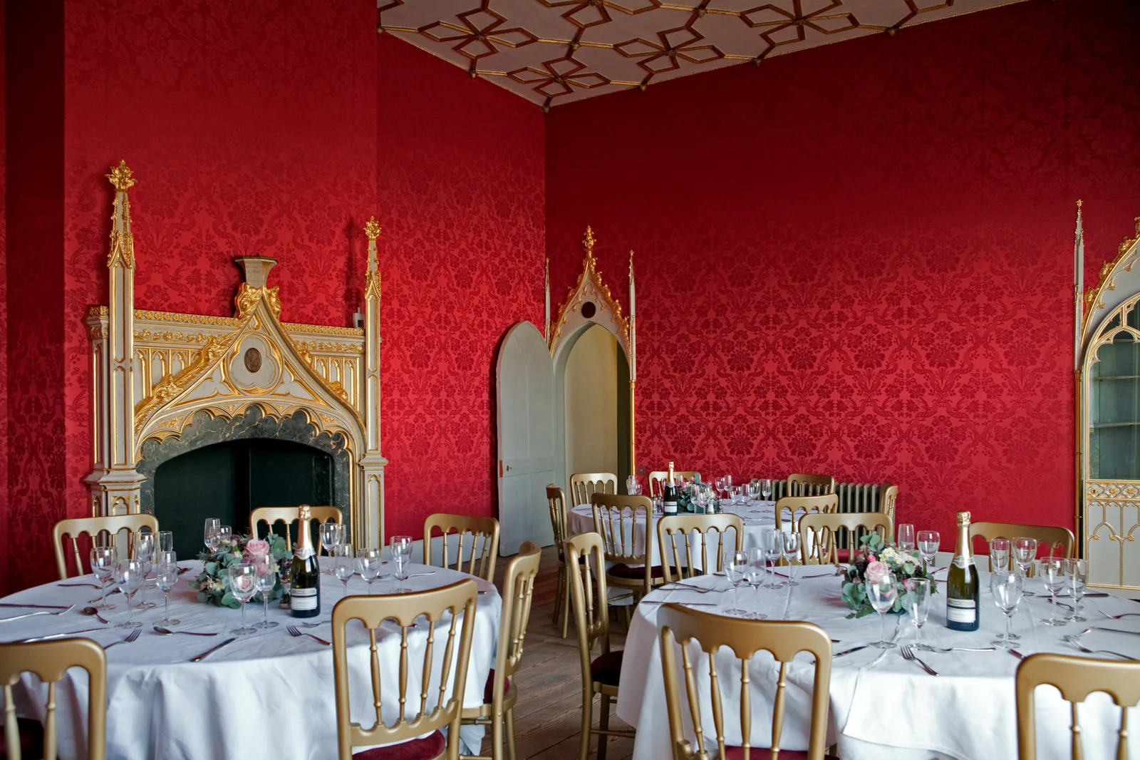 An ornate red room set with a long dining table at Strawberry Hill House