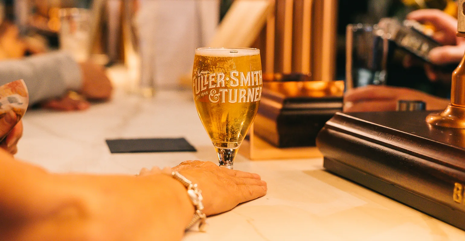 A pint being served at the pub counter at Ye Olde Mitre