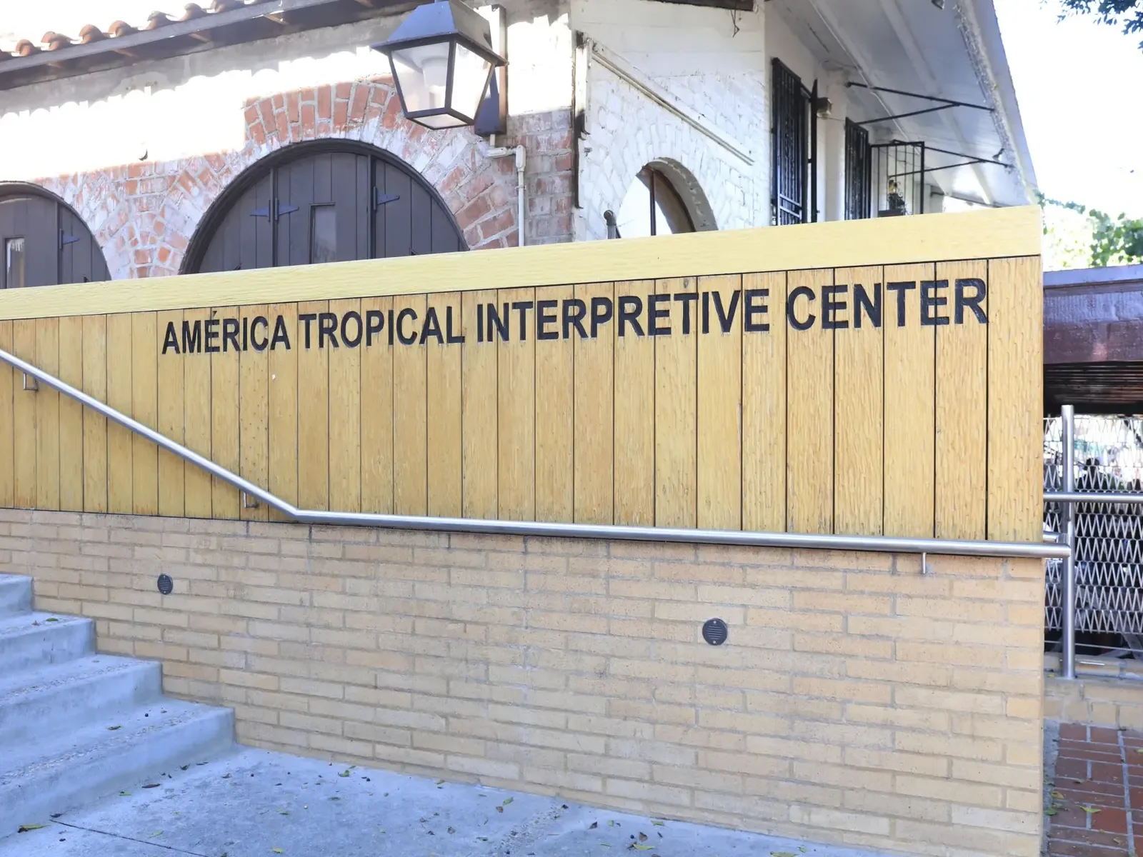 The interpretive centre entrance beside a brick walkway at América Tropical Interpretive Center