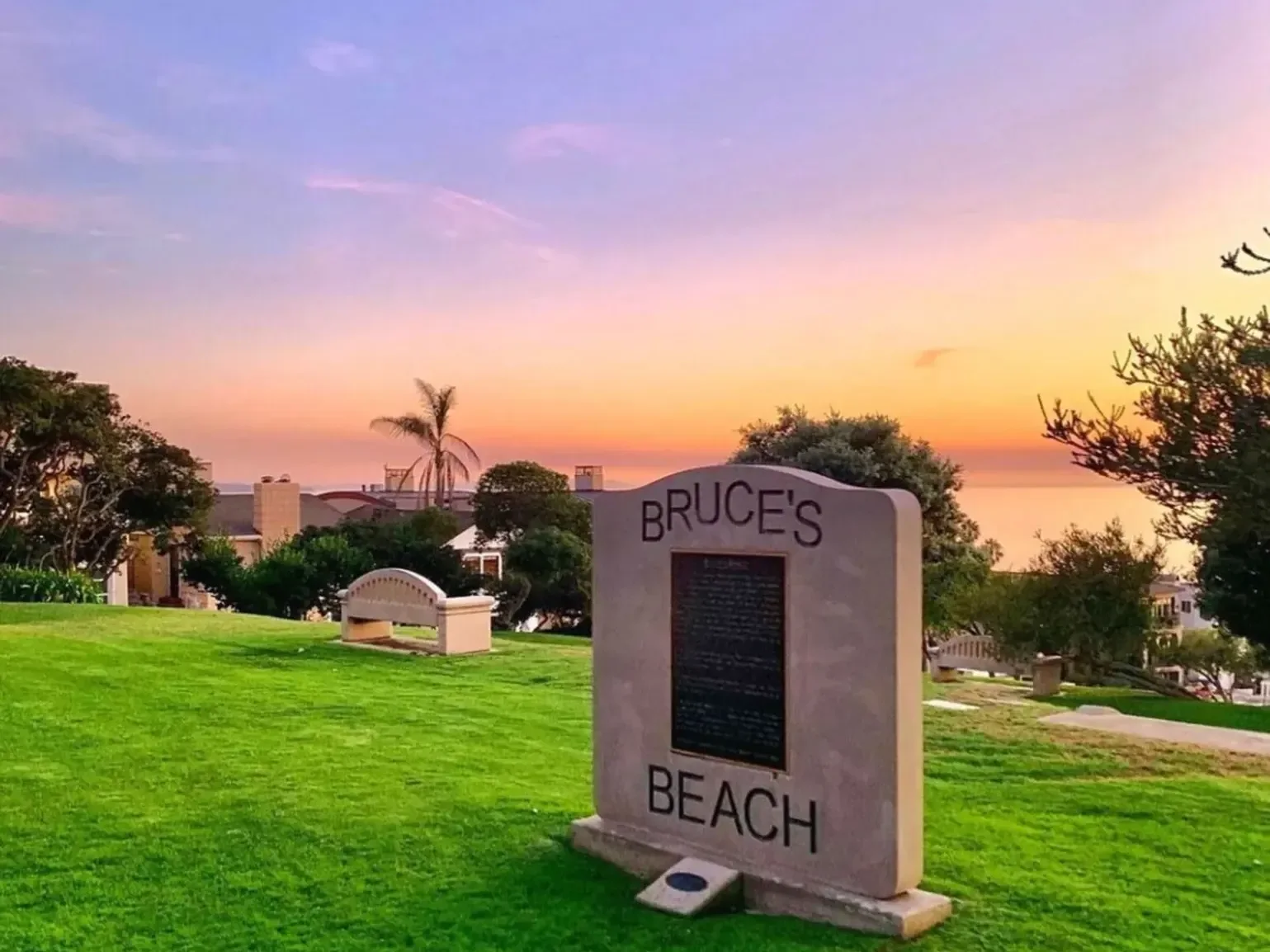 The park's memorial stone against a sunset sky at Bruce's Beach
