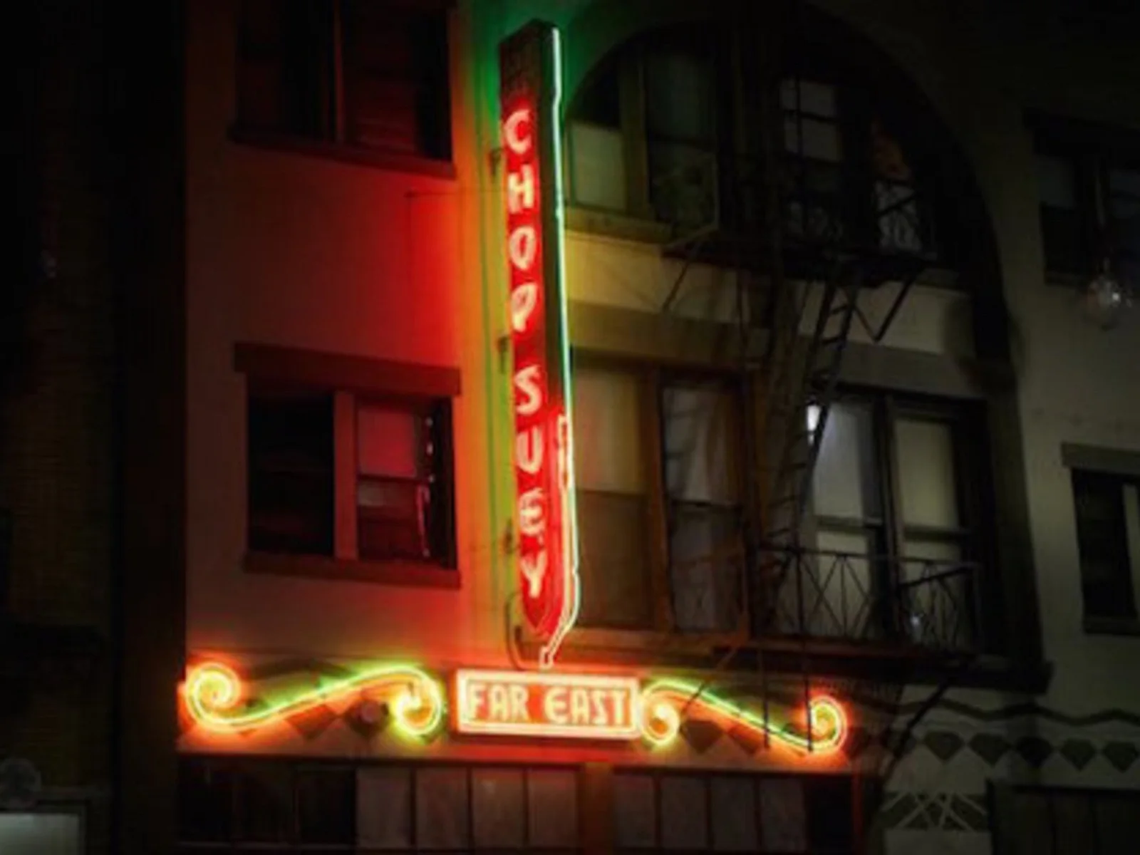 The illuminated entrance sign seen at night at Far Bar
