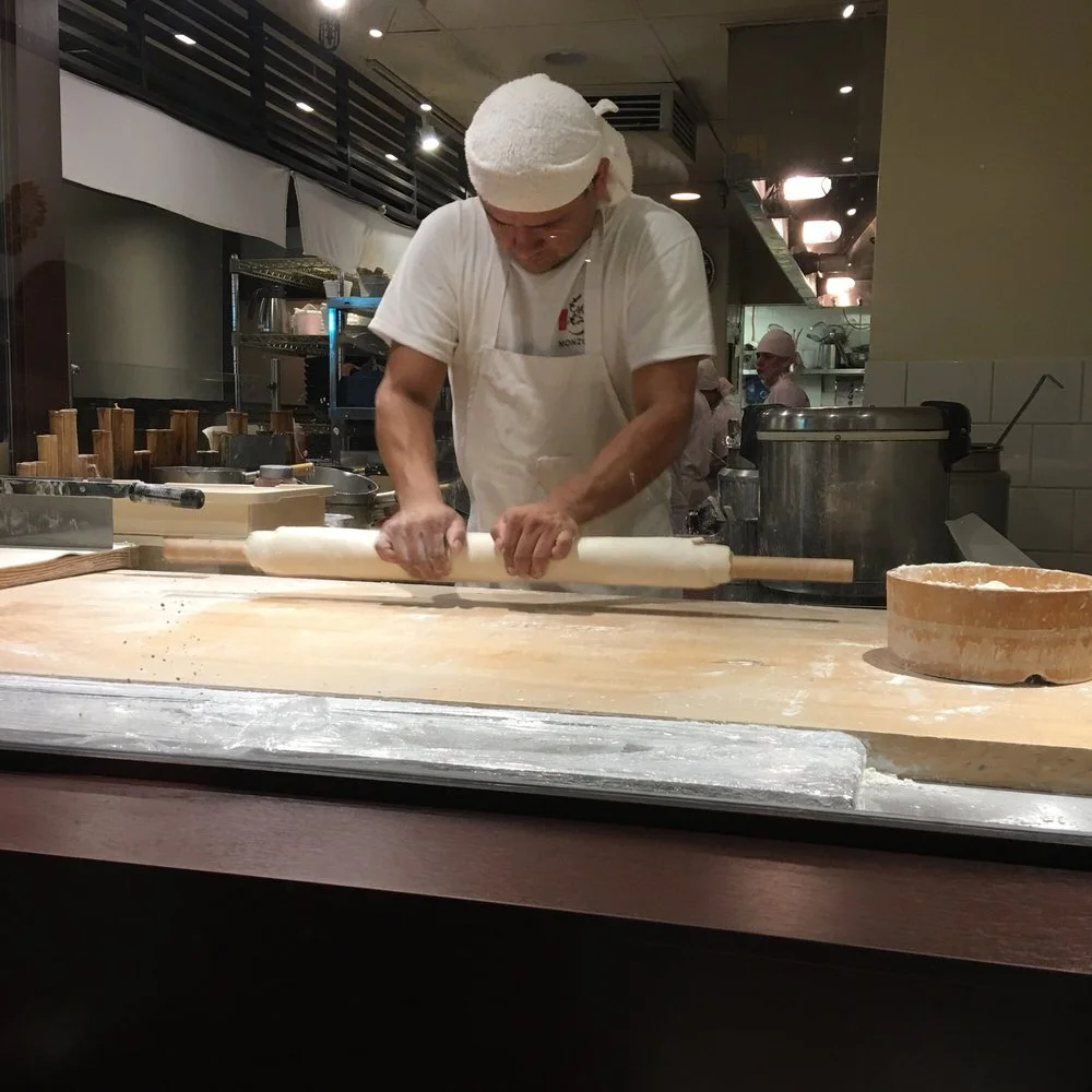 A cook preparing noodles at the counter at Marugame Monzo
