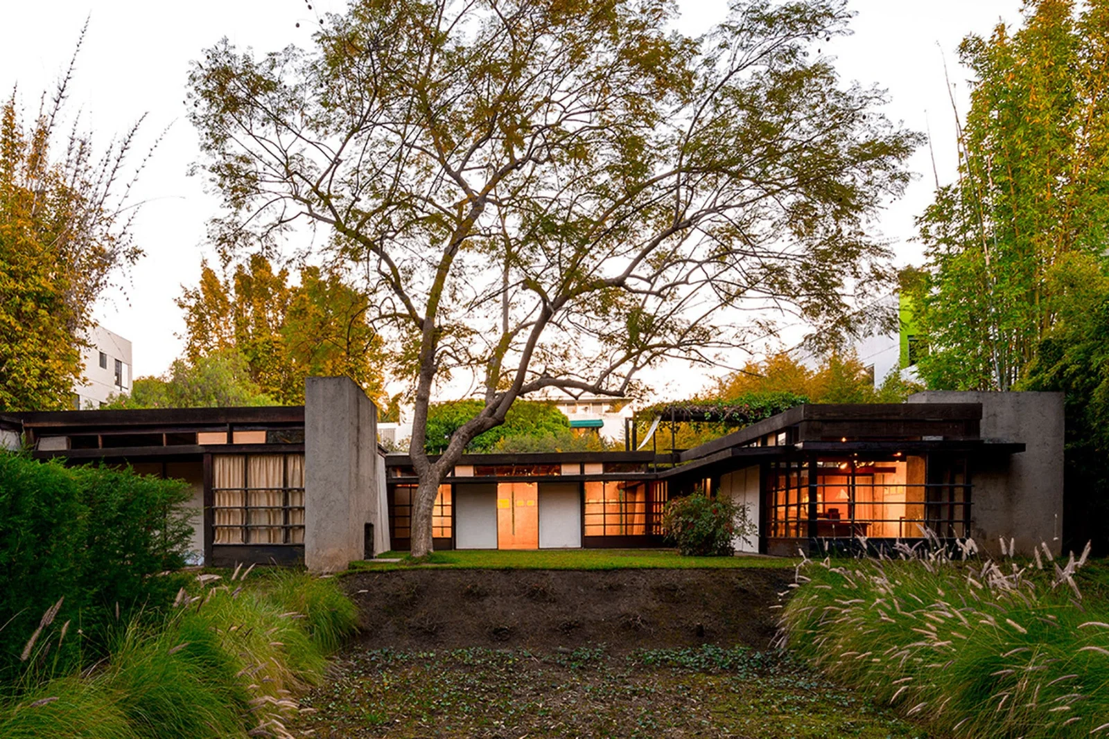 The house and garden illuminated at dusk at Schindler House, MAK Center