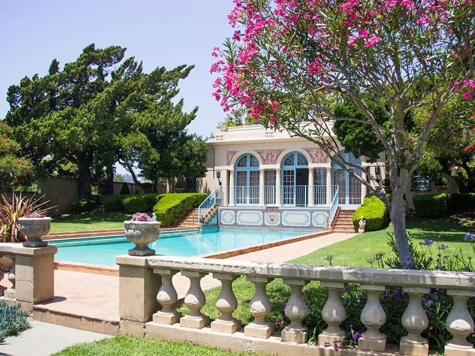 The garden pavilion, pool and flowering trees at Virginia Robinson Gardens