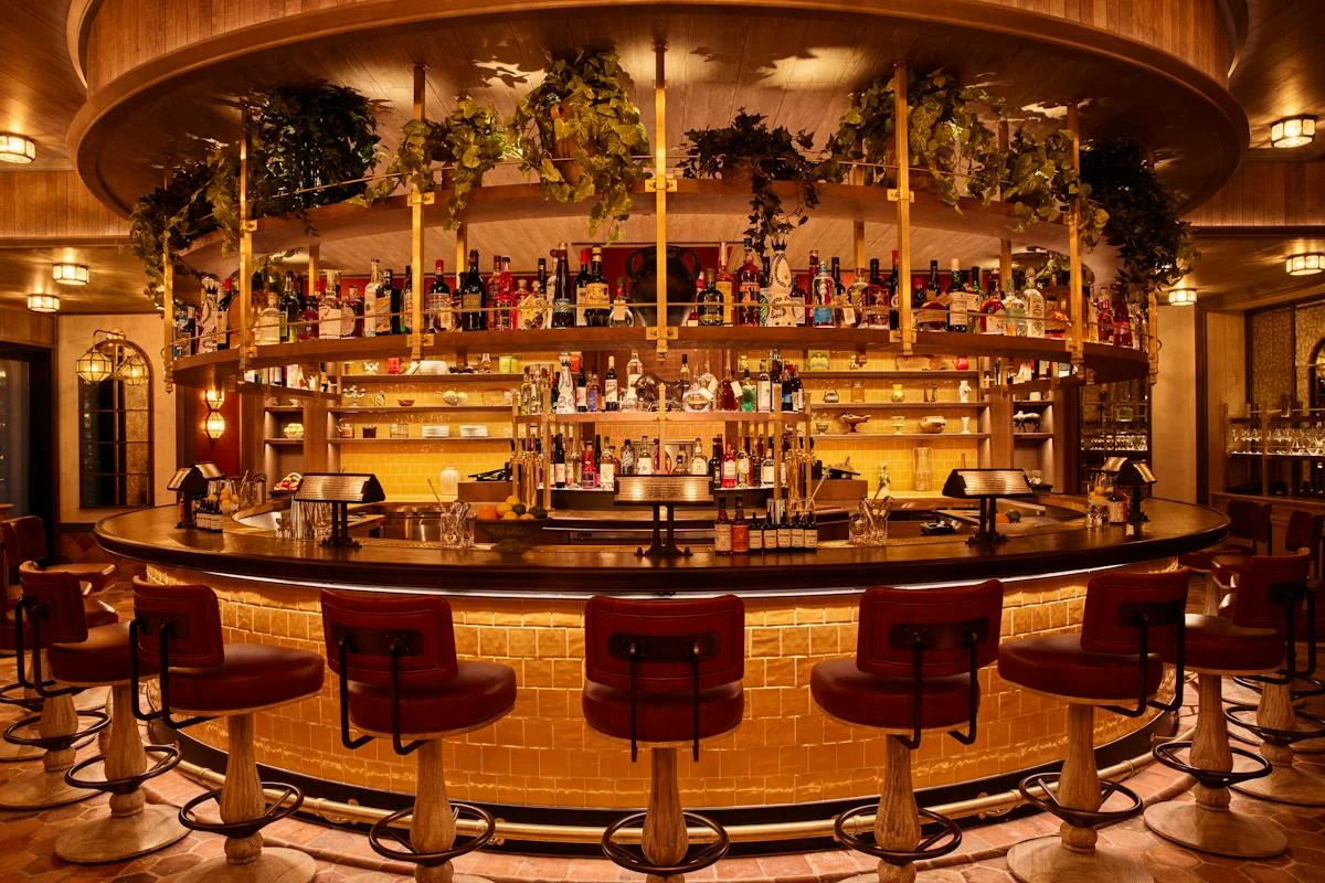 The warmly illuminated bar with red leather stools at Carne Mare