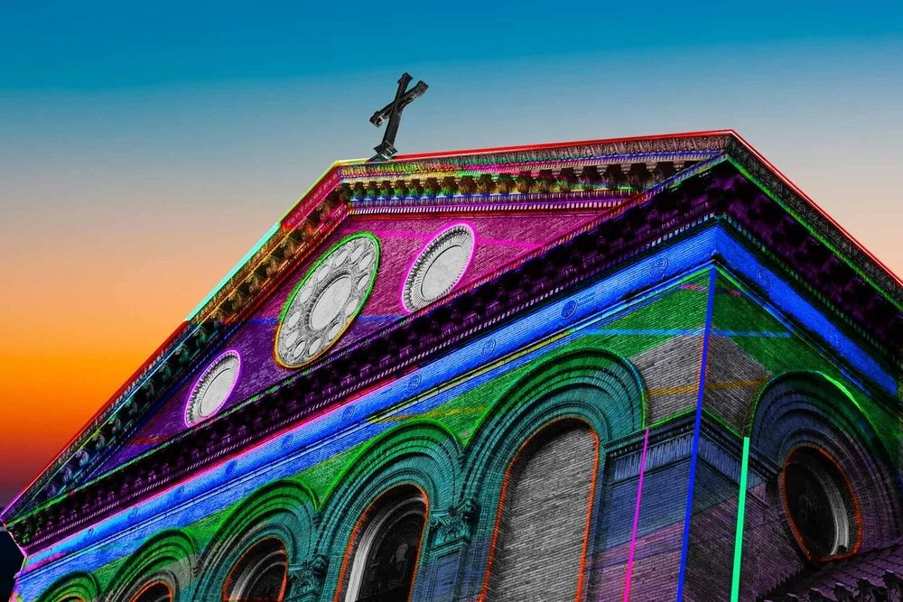 The church facade illuminated with rainbow colours at Judson Memorial Church