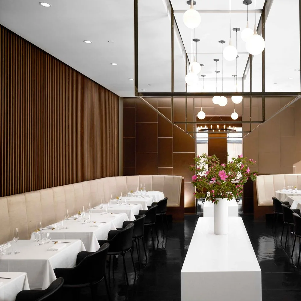 A bright dining room with a long upholstered banquette at Jungsik New York