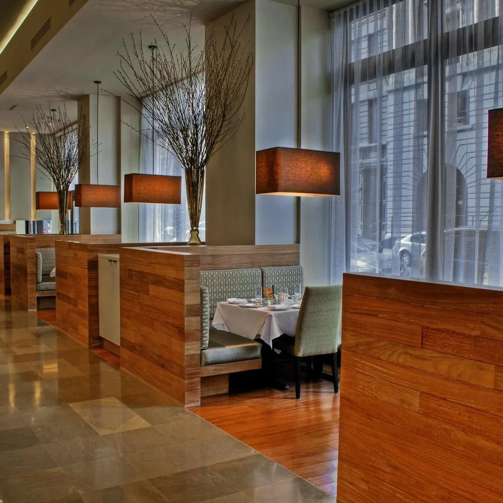 Wooden partitions and pendant lamps beside tall windows at Tamarind