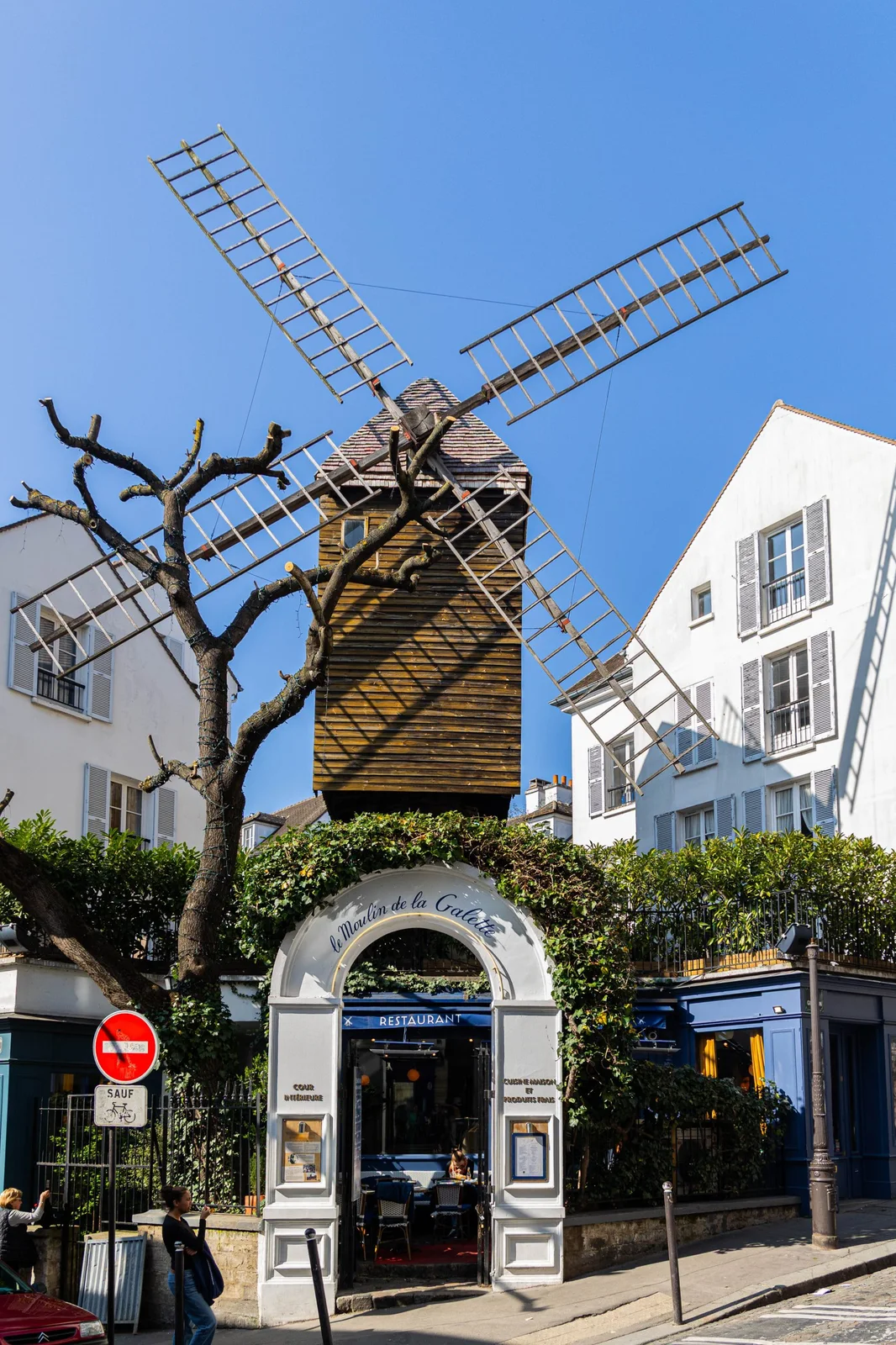 The restaurant entrance beneath its historic windmill at Le Moulin de la Galette