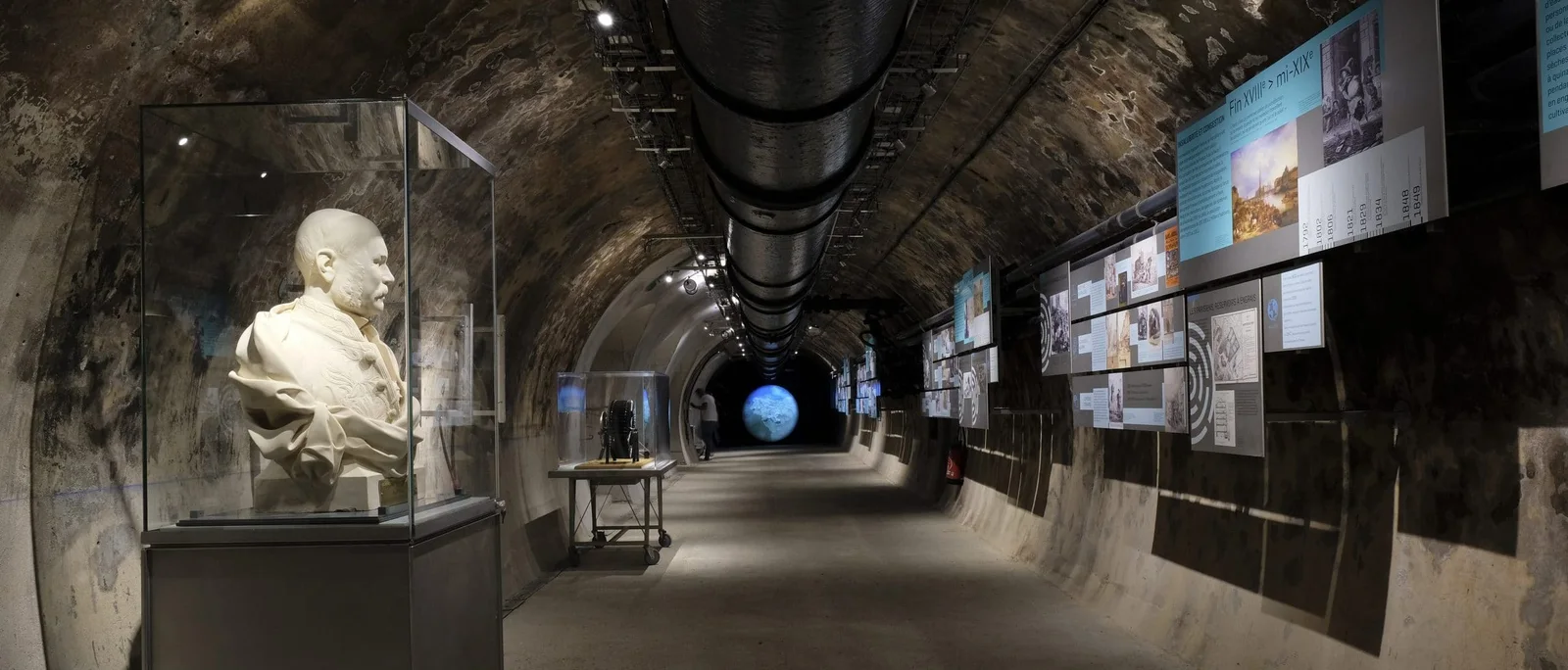 Museum displays inside a stone-walled underground passage at Paris Sewers Museum