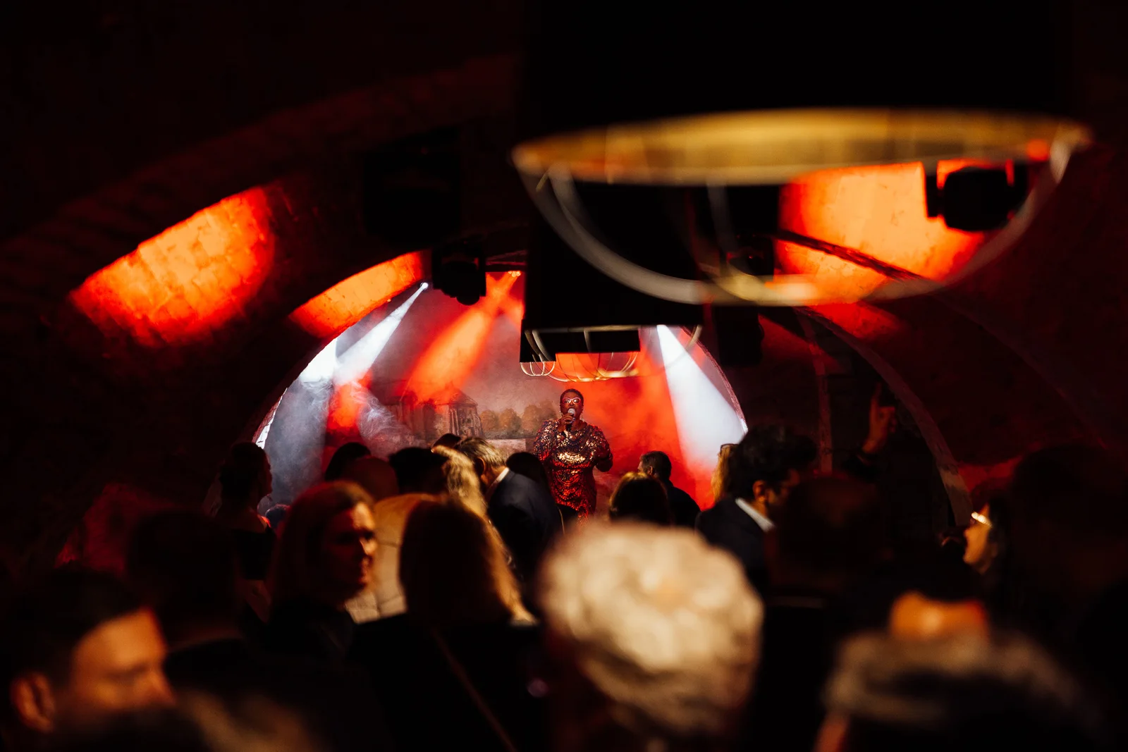 Guests beneath warm lights in the vaulted event space at Le M. Musée du Vin