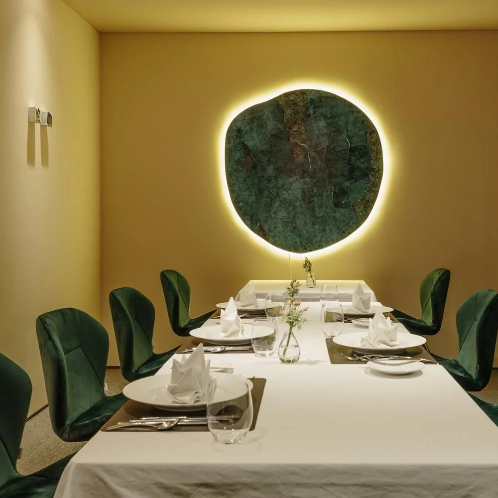 L'Amitié: white linen tables and green chairs