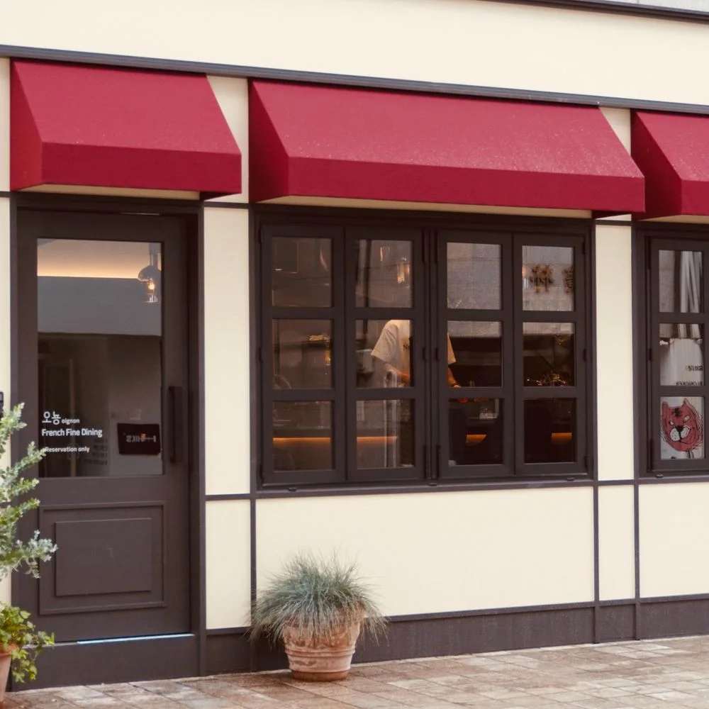 L'OIGNON: restaurant facade with red awnings