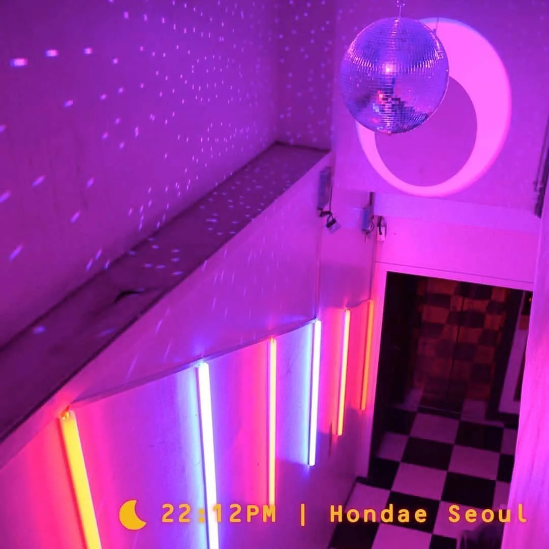 MODECi: neon-lit staircase and entrance with pink and purple lighting
