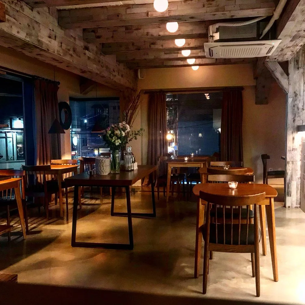 Osteria Orzo: evening dining room with wooden tables