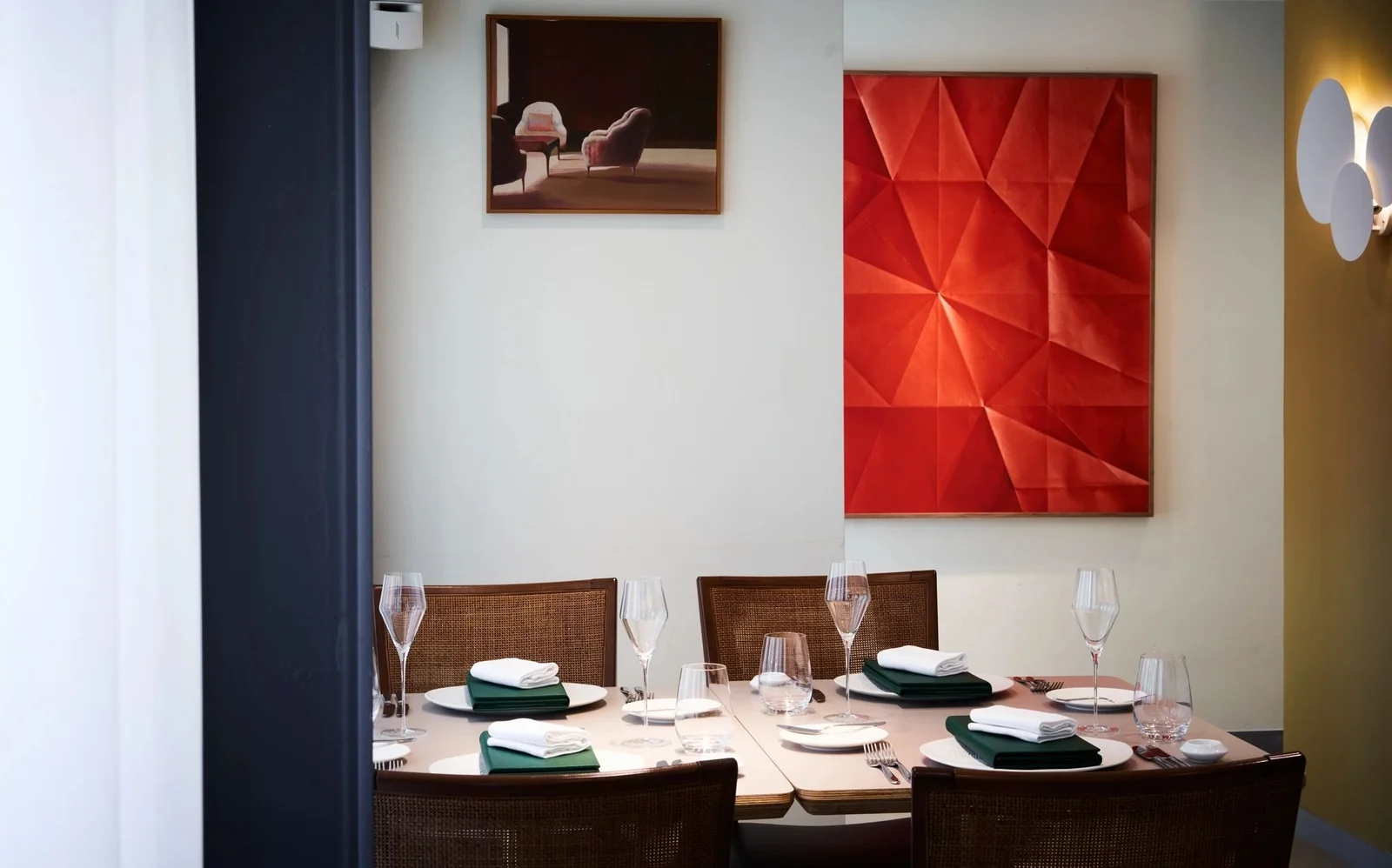 A dining table beside colourful wall art at Restaurant OY
