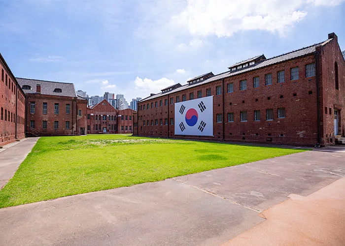 The former prison's brick buildings surrounding a green courtyard at Seodaemun Prison History Hall
