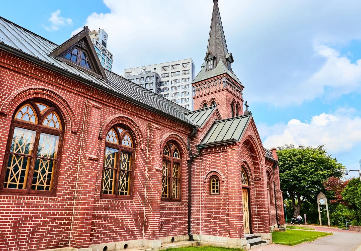 The church's red-brick facade and pointed tower at Yakhyeon Catholic Church